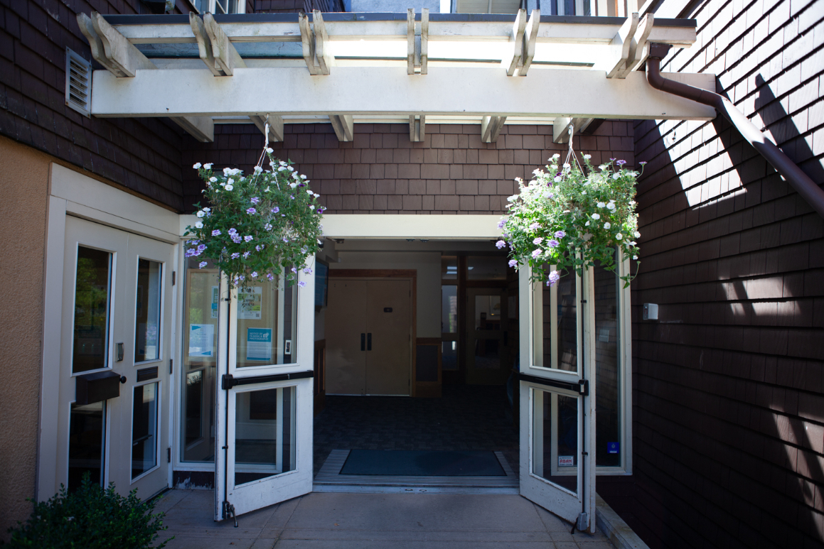 Main building entrance where you enter to access the office - doors are white open with flowers pots